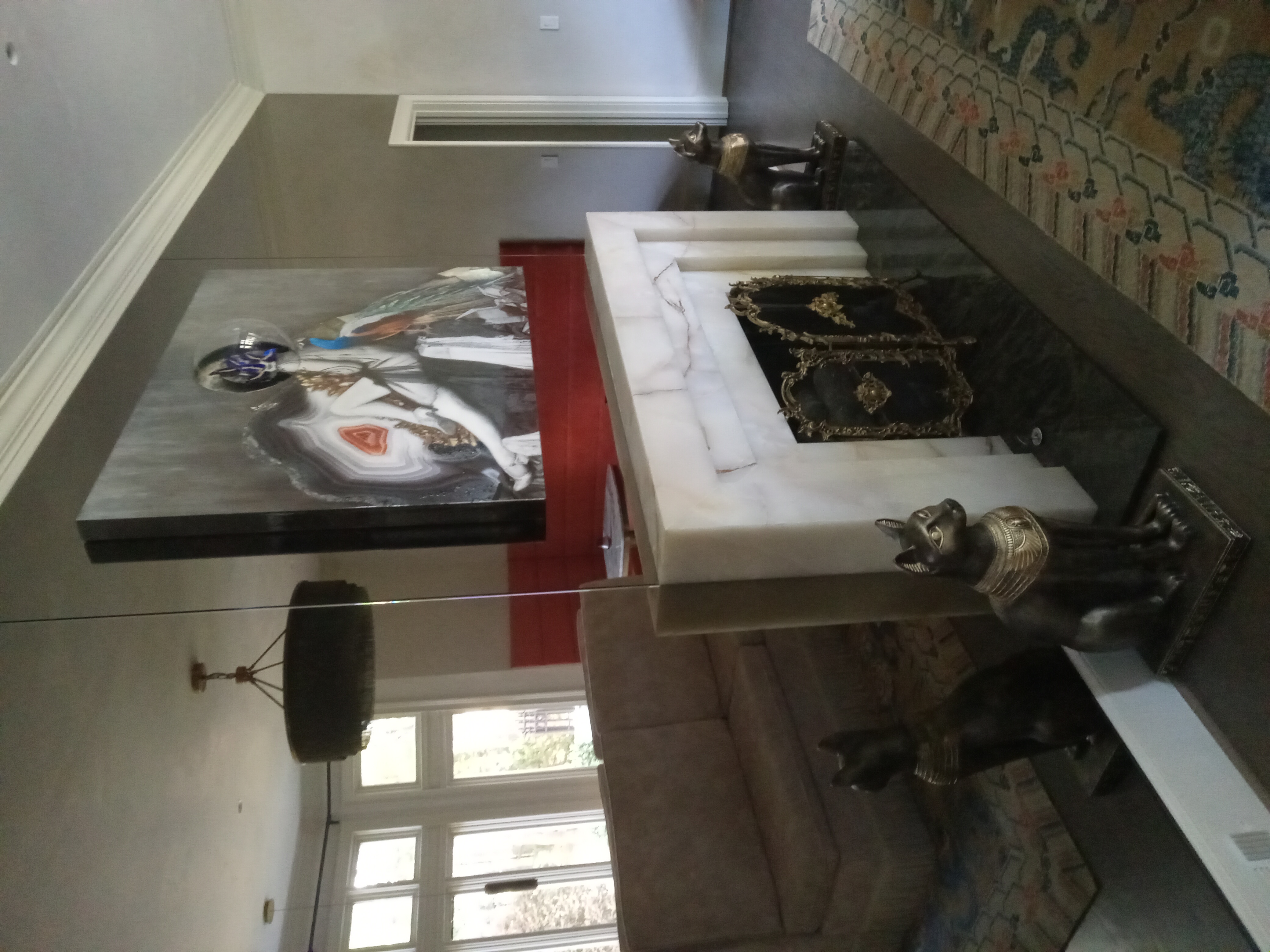 This bronze mirror wall was cut custom to surround a marble fireplace and accept mounting brackets for a custom commissioned art piece. What a stunning project! We are thrilled to have been a small part of it!