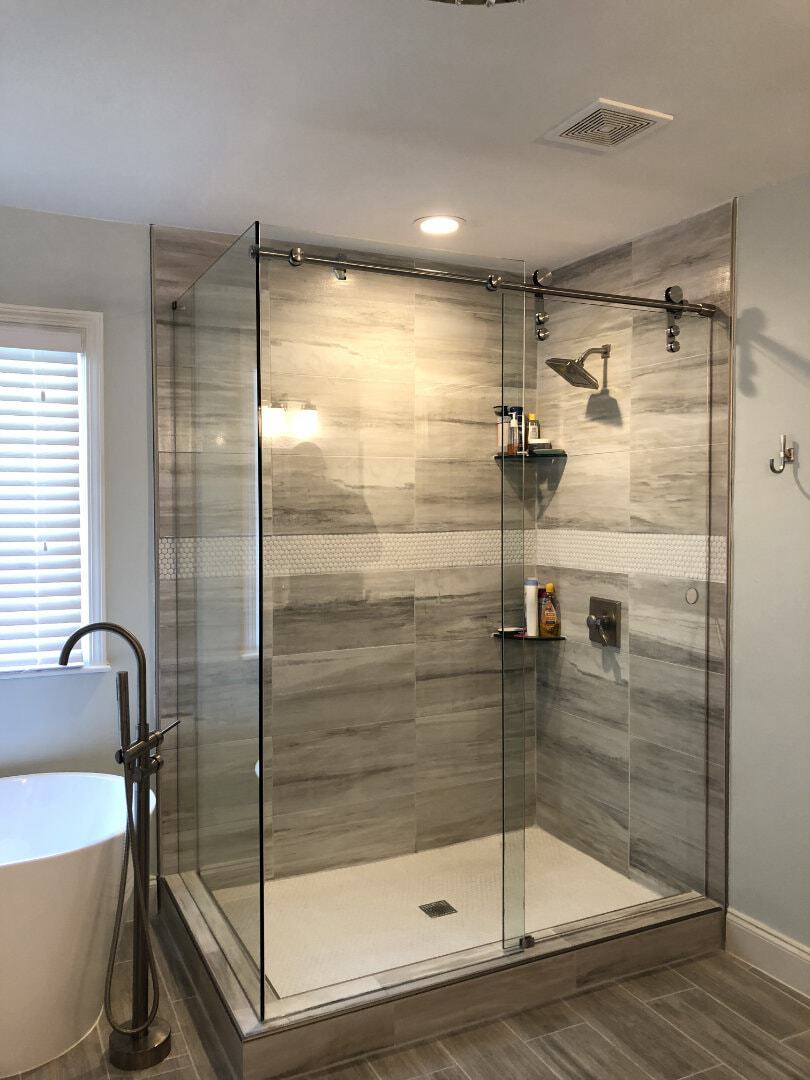 This sliding option is called a PL80 from Alumax. Notice how the door hangs underneath the bar so that it is slightly shorter than the rest of the enclosure. We like to use this sliding option on curbs that are narrow as this system has a smaller footprint compared to other barn-style slider options.