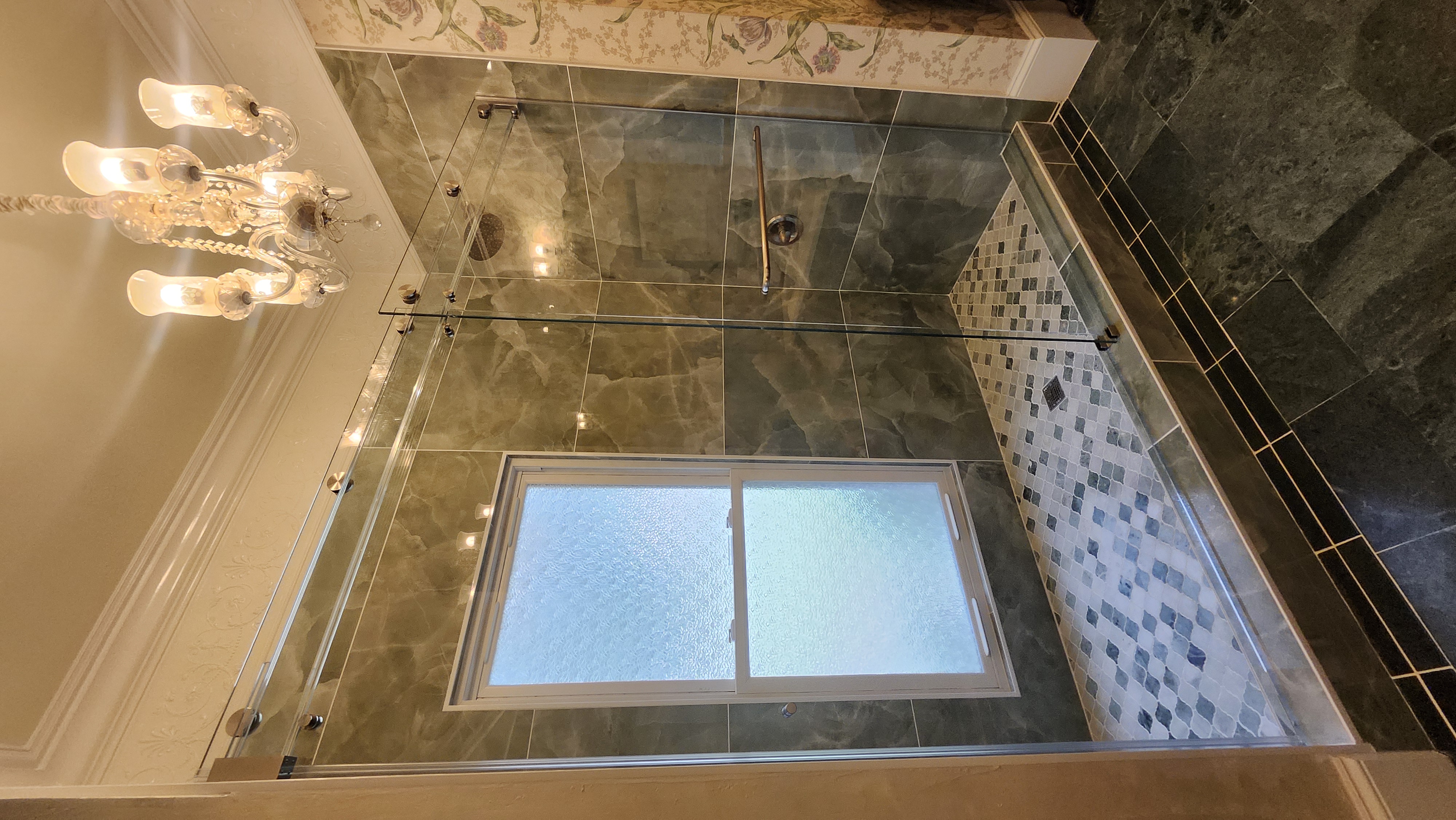 This is a Phantom Series Slider with 3 roller carriages per door to hold the weight of this oversized double sliding system. The bar is triple laminated with low iron glass!