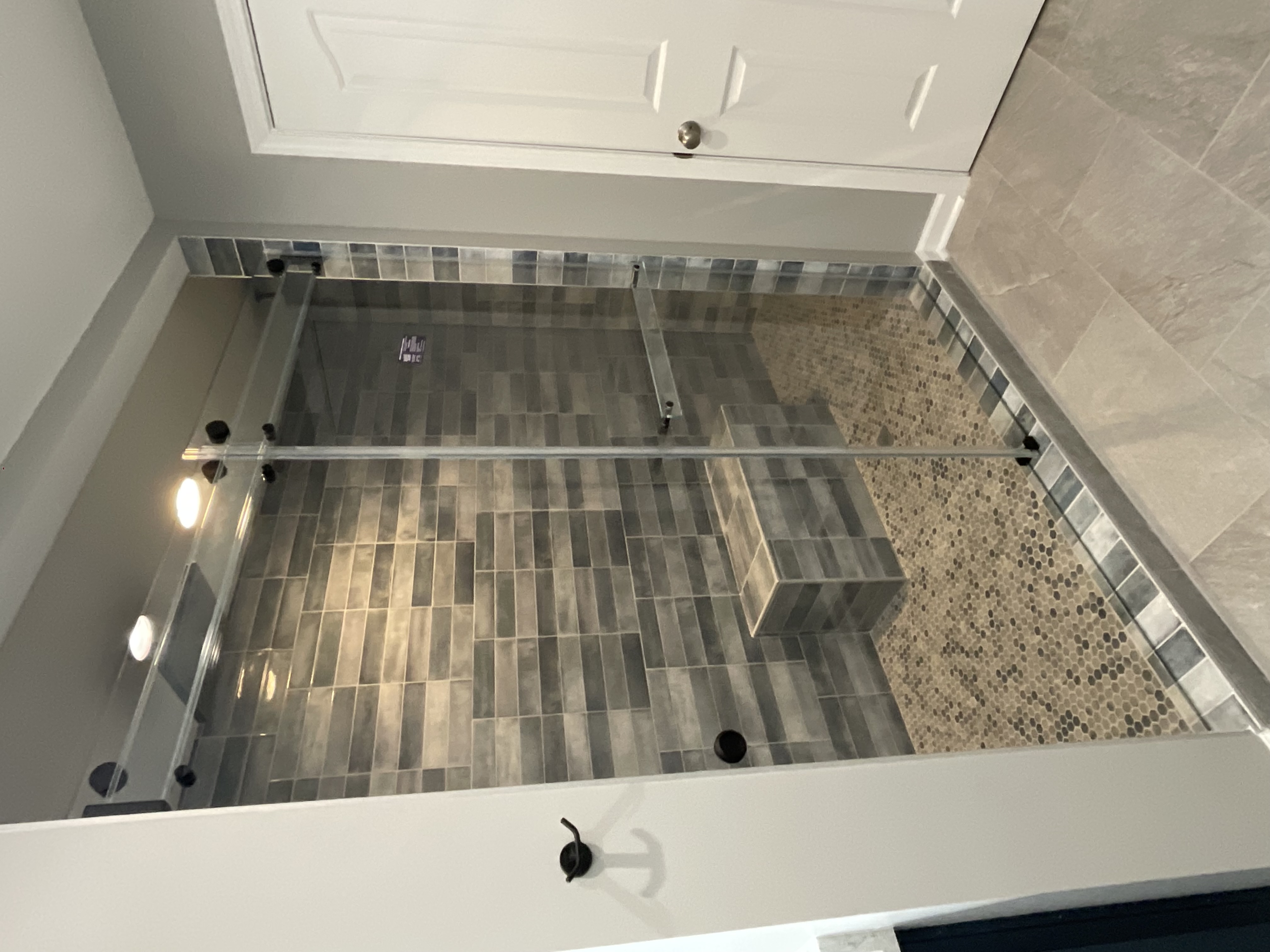 This is a Phantom sliding shower enclosure with matte black fittings and a glass towel bar!